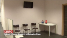 Ecran d'affichage en salle d'attente poste médical de garde à Jambes avec distributeur de tickets pour file d'attente - Expansion TV